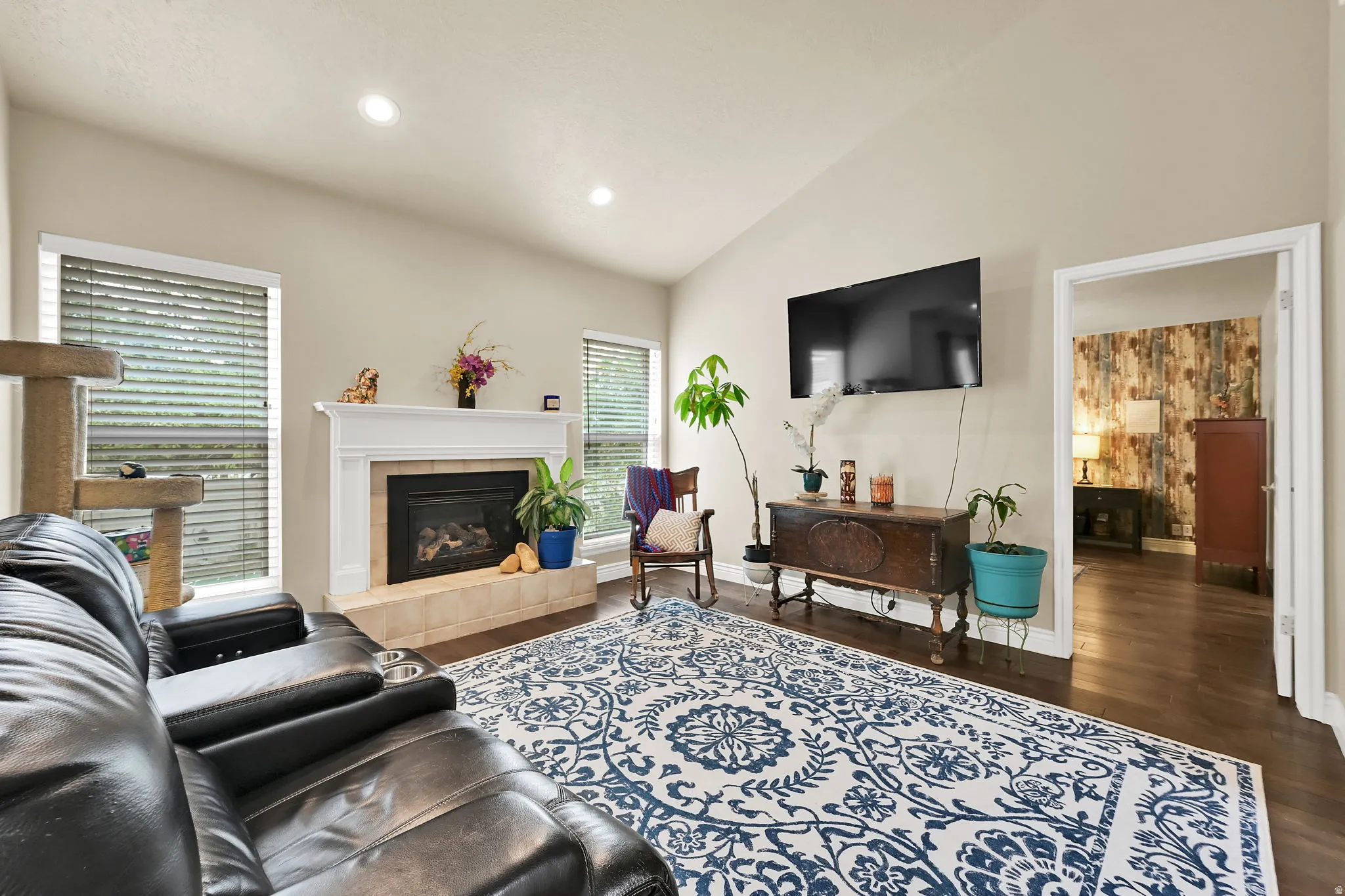 Living area featuring a fireplace with a white mantel and tiled hearth