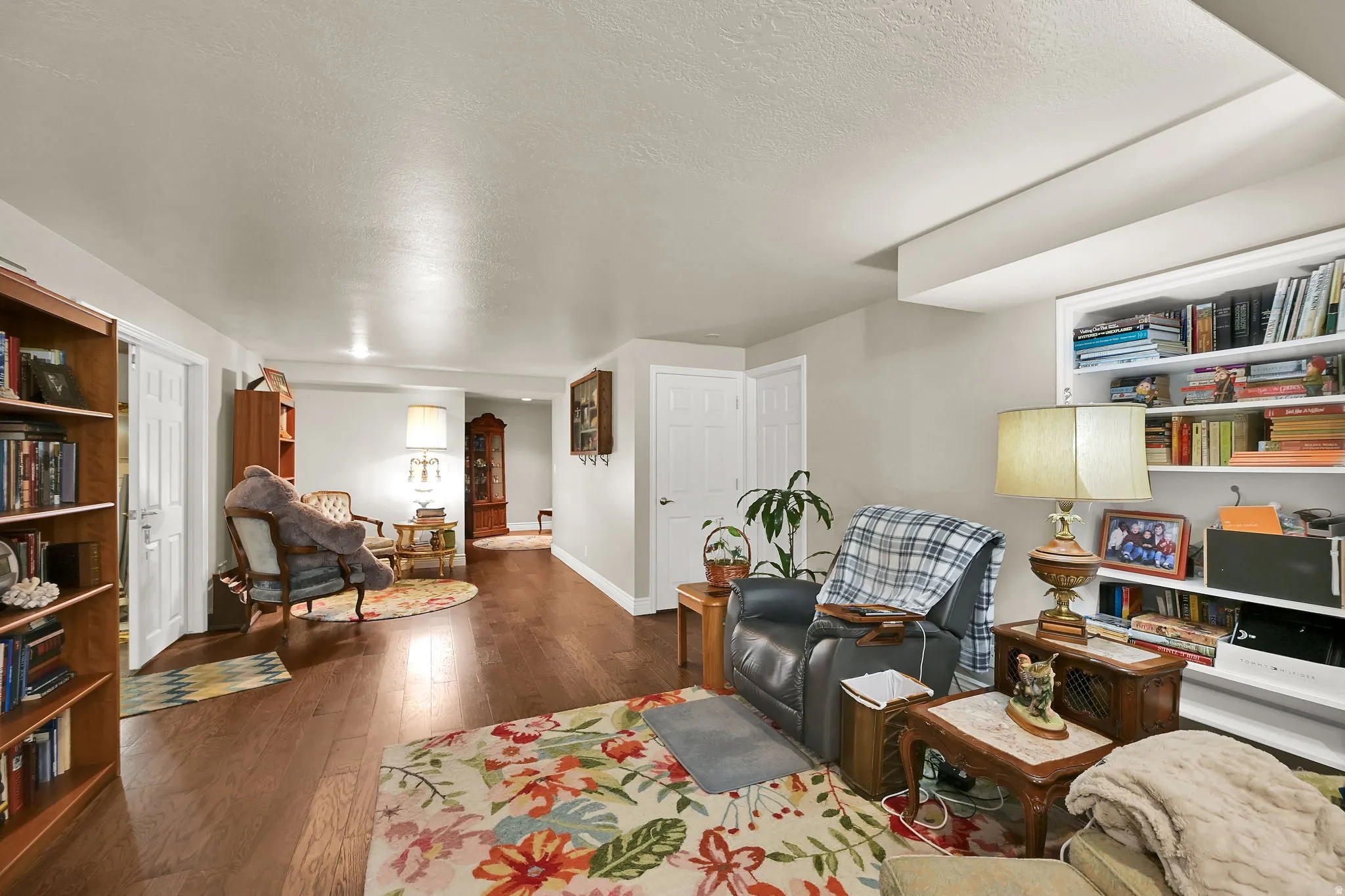 Spacious interior featuring wood-finish flooring, built-in shelving, white trim, and light-colored walls