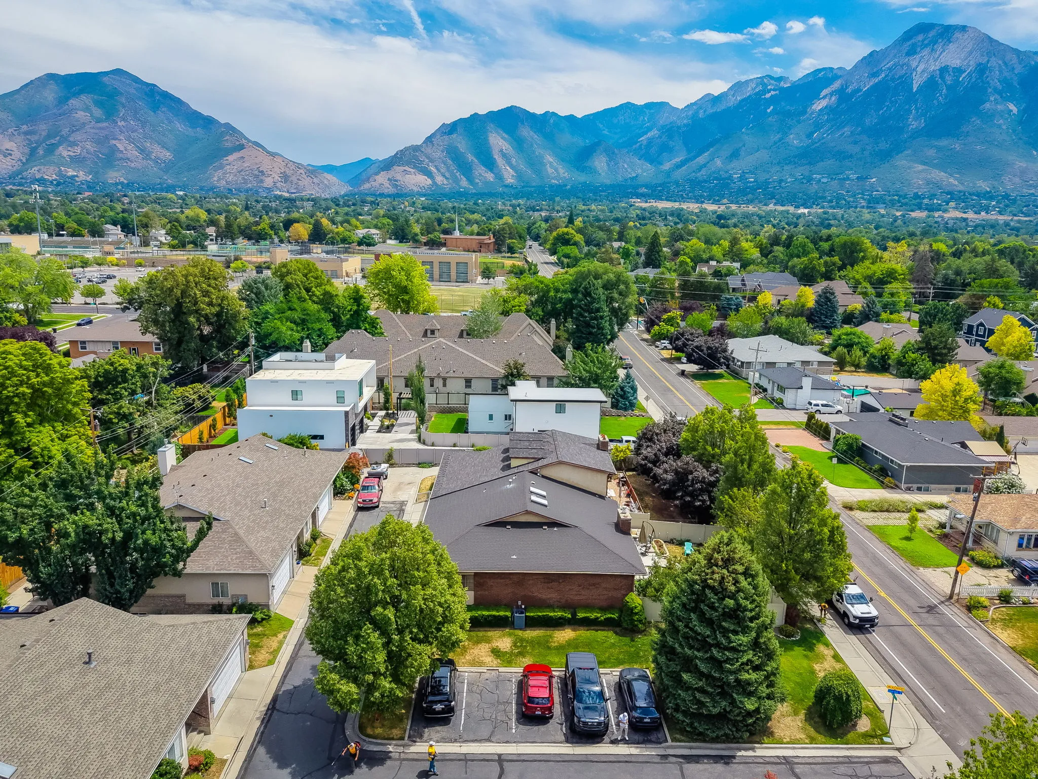 Aerial perspective showcasing a residential neighborhood with a backdrop of prominent mountains and a clear sky