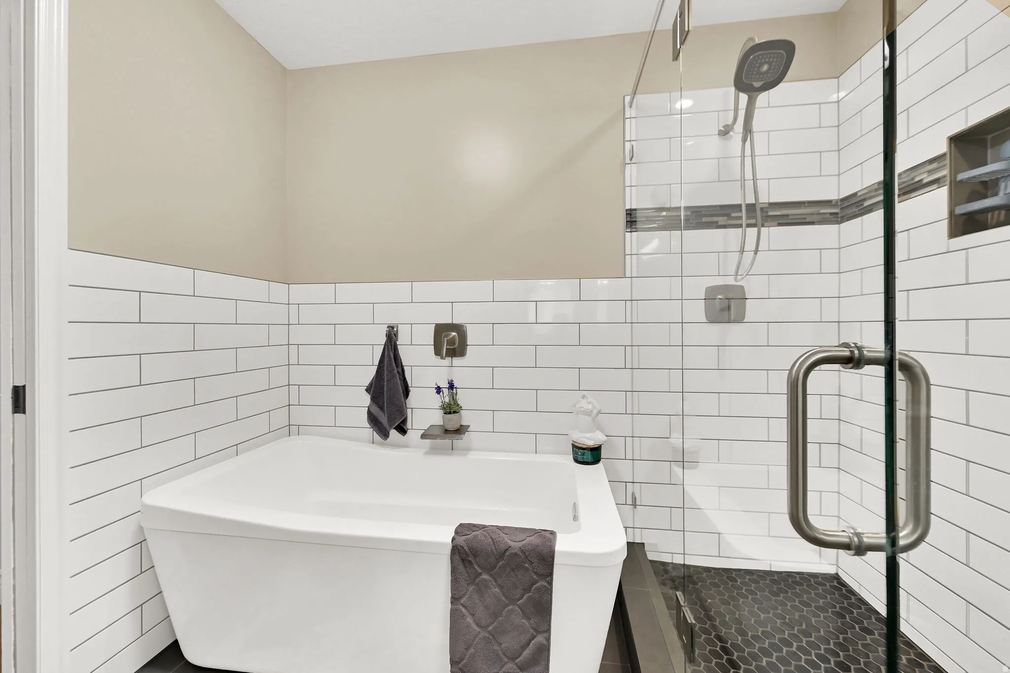 Contemporary soaking tub complemented by white subway tile wainscoting