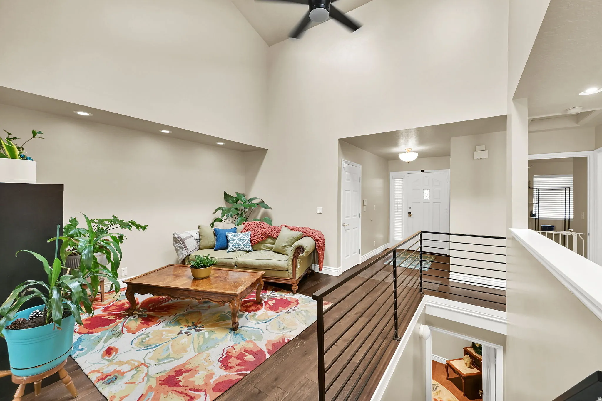 High ceilings featuring a ceiling fan, recessed lighting, and wood-finish flooring