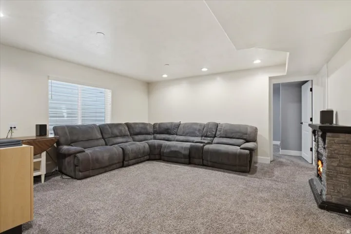 Spacious room featuring neutral carpeting, recessed lighting, and a window with blinds