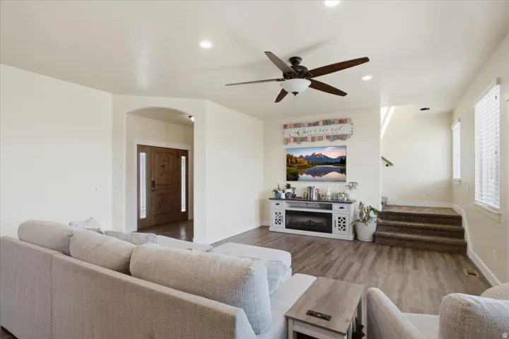 Spacious living area featuring wood-finish flooring, recessed lighting, and a ceiling fan