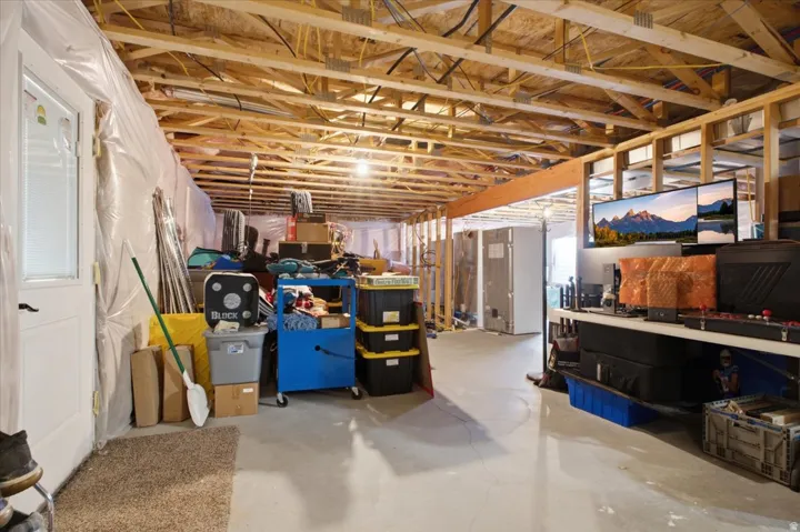 Unfinished basement with exposed wood joists and structural framing