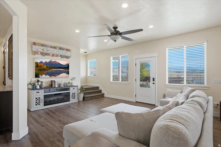 Spacious open-concept living area featuring wood-finish flooring, recessed lighting, and a ceiling fan