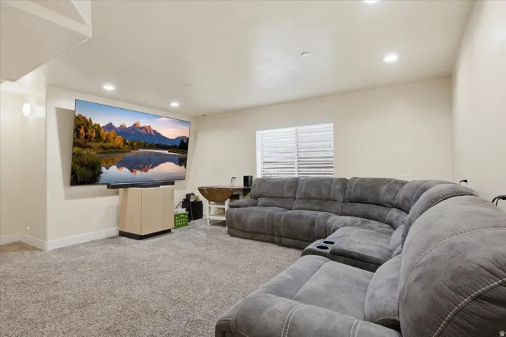 Recessed lighting illuminates this carpeted room featuring a window with horizontal blinds