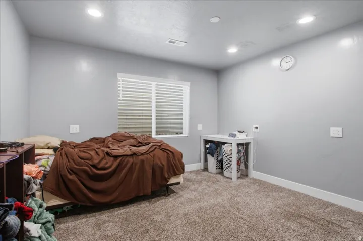 Room featuring a window with horizontal blinds, neutral-toned walls, recessed lighting, and carpet flooring