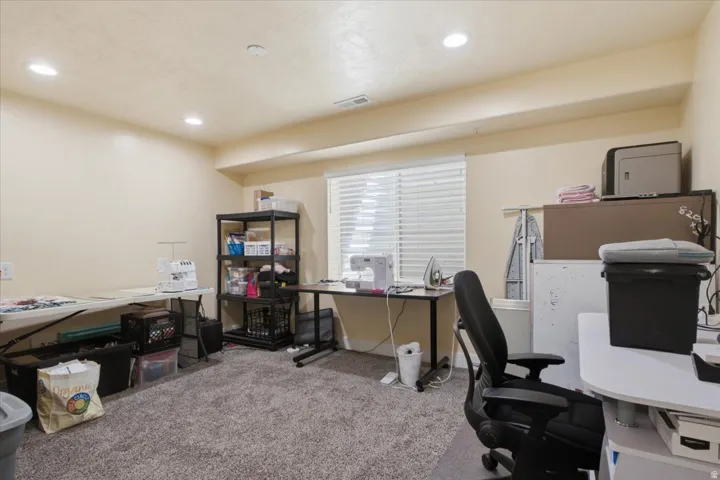 Recessed lighting illuminates this versatile room with plush carpeting