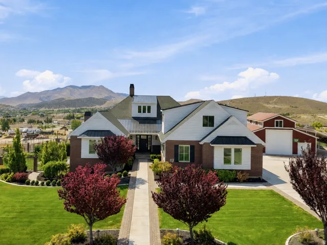 Custom-built residence featuring a brick and white siding exterior, a two-story design, and a gabled roofline