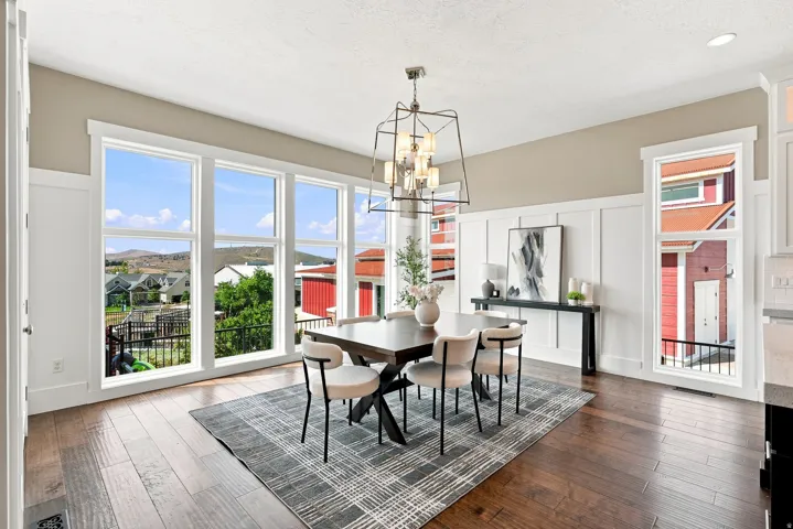 Dining area featuring wide plank wood-finish flooring and extensive wainscoting