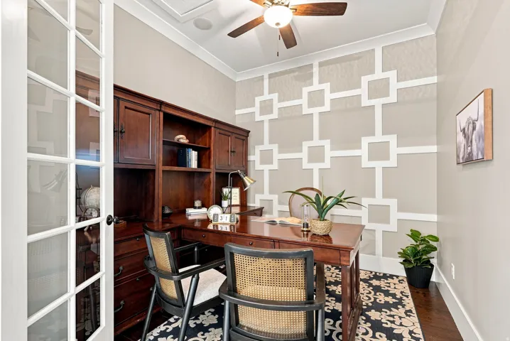Room featuring French doors, dark wood-finish built-in cabinetry, decorative wall paneling, crown molding, and wood-finish flooring