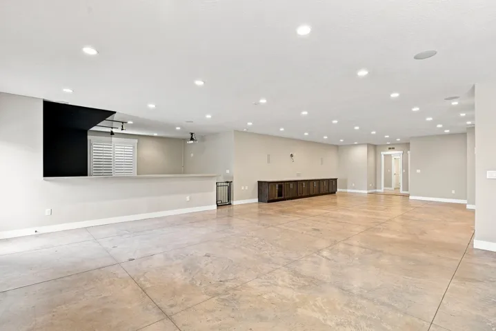 Expansive open-concept room featuring concrete flooring and recessed lighting