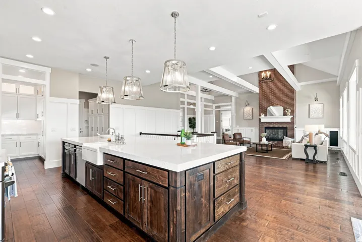Expansive kitchen island with a white countertop and integrated farmhouse sink