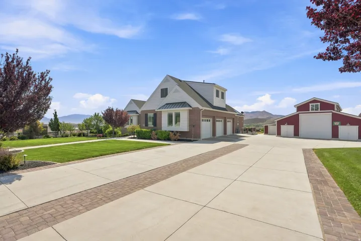 Spacious property with a light brick and white siding main residence, featuring a multi-car garage