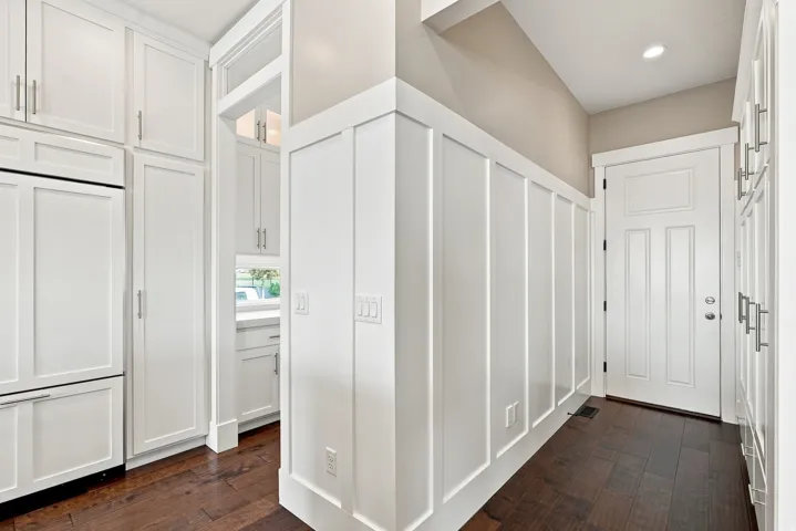 Entryway featuring dark wood-finish flooring, white paneled accent wall, and a recessed ceiling light