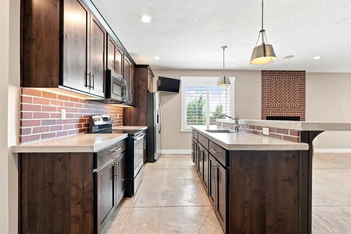 Modern kitchen featuring dark wood-finish cabinetry and light-toned countertops