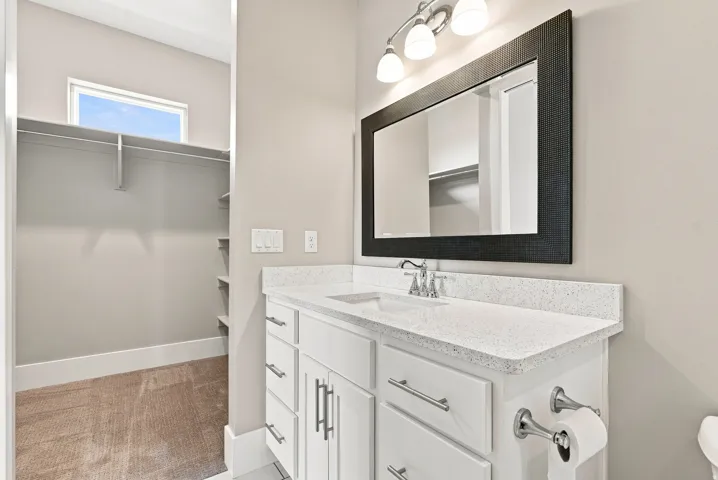 Vanity featuring a white quartz countertop, undermount sink, and polished chrome faucet