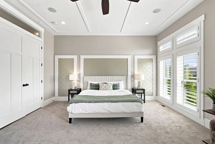 Carpeted interior space featuring a tray ceiling with recessed lighting and a ceiling fan