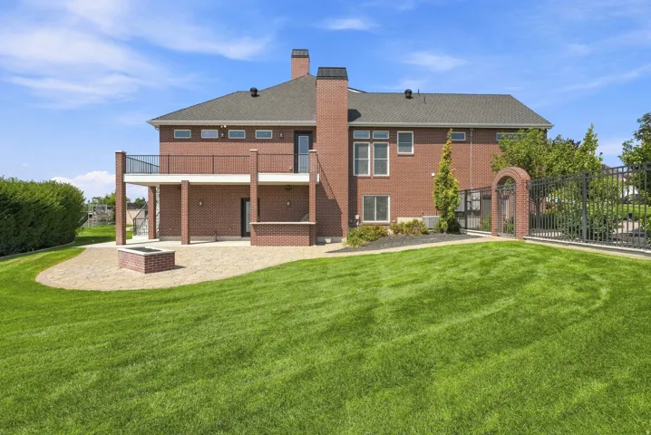 Brick exterior with a second-story deck featuring black railings and support pillars