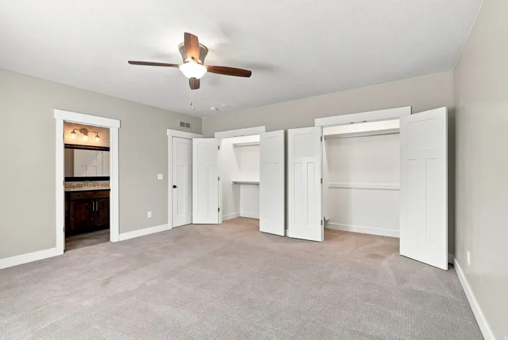 Spacious room with light gray walls and neutral carpeting