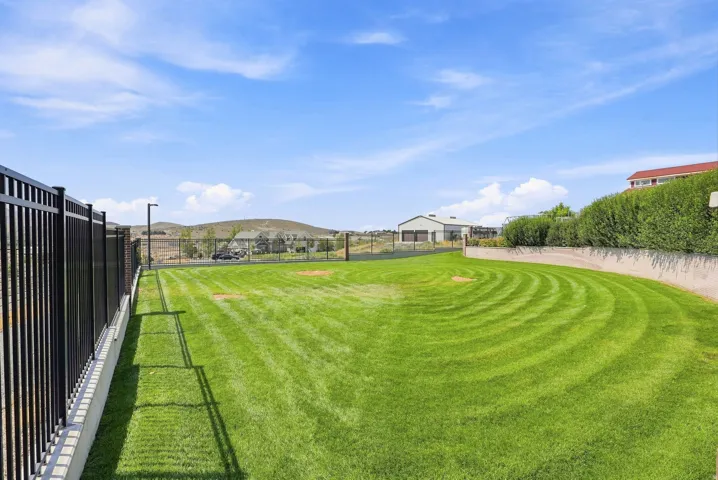 Expansive outdoor lawn area featuring a manicured grass surface with distinct mowing patterns