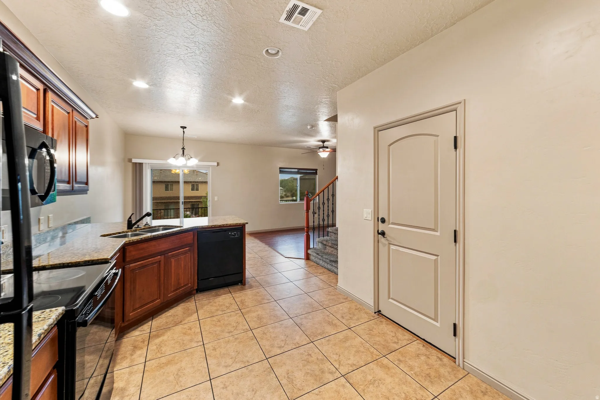 Kitchen featuring wood cabinetry, granite countertops, and tile flooring