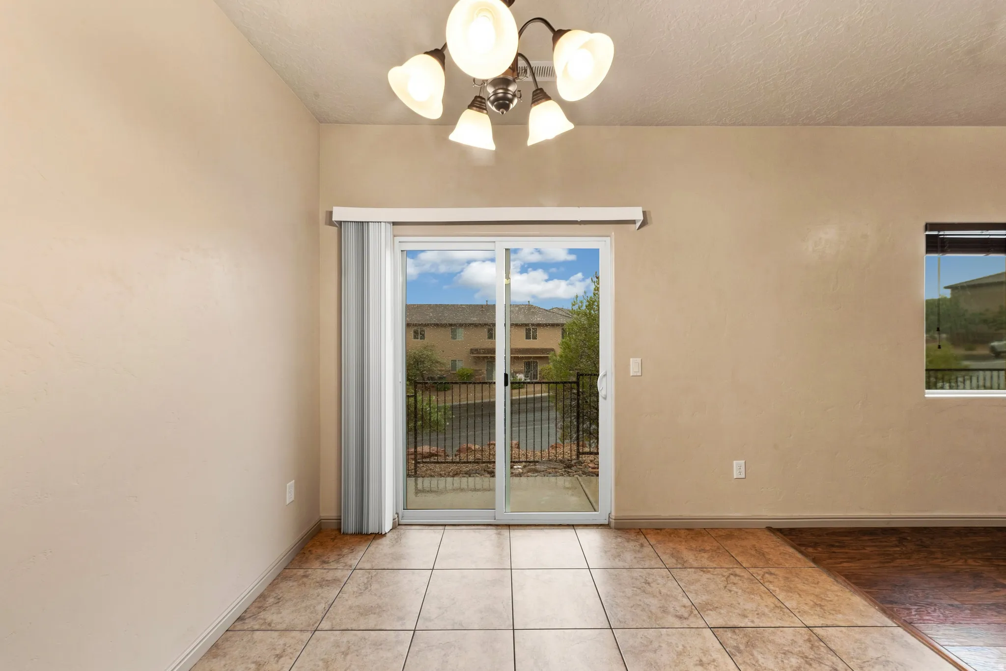 Sliding glass door opening to an outdoor patio with a metal railing