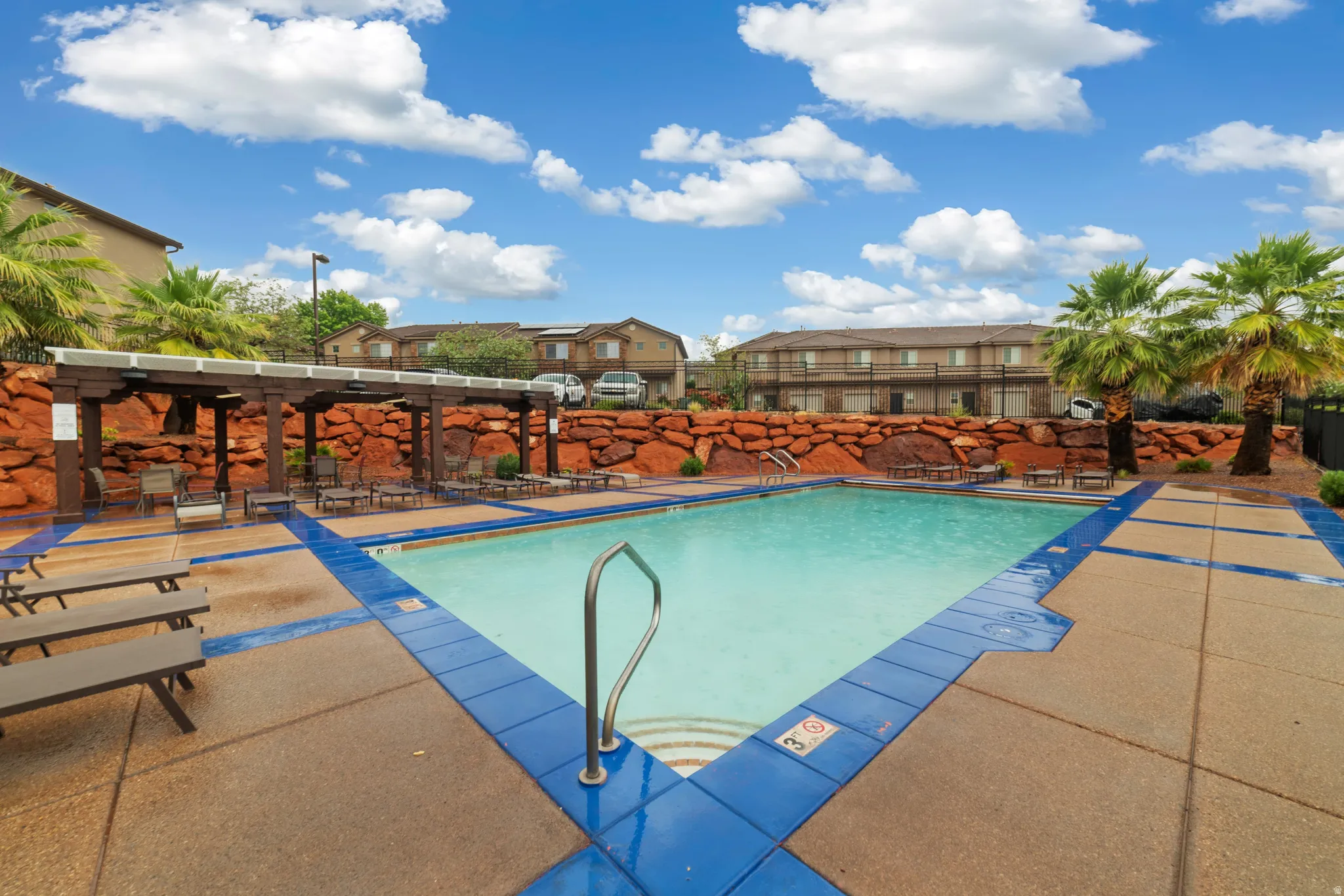 Community swimming pool with blue tile border and integrated steps