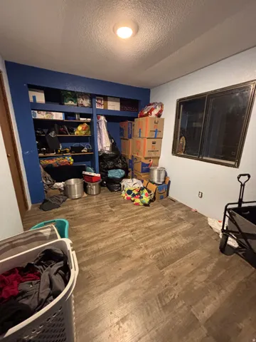 Wood-finish flooring throughout, complemented by a built-in shelving unit with multiple storage compartments