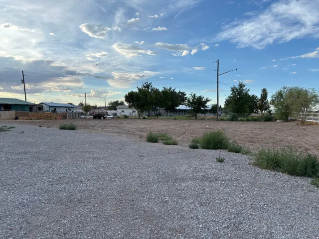 Expansive gravel lot with a cleared, level parcel beyond