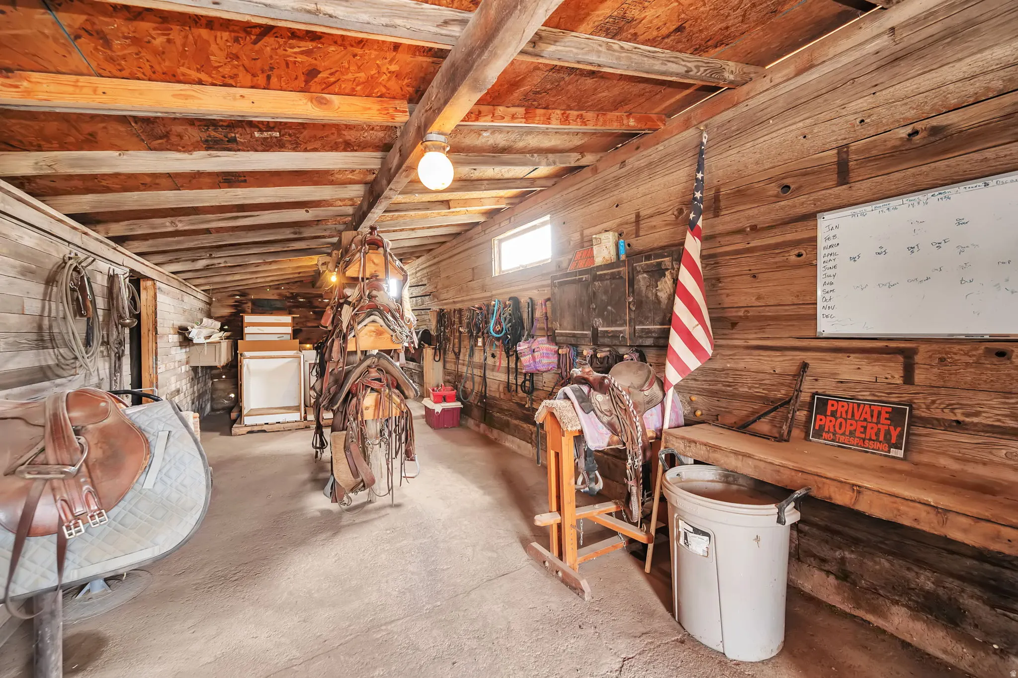 Rustic outbuilding interior featuring exposed wood beams and plank walls