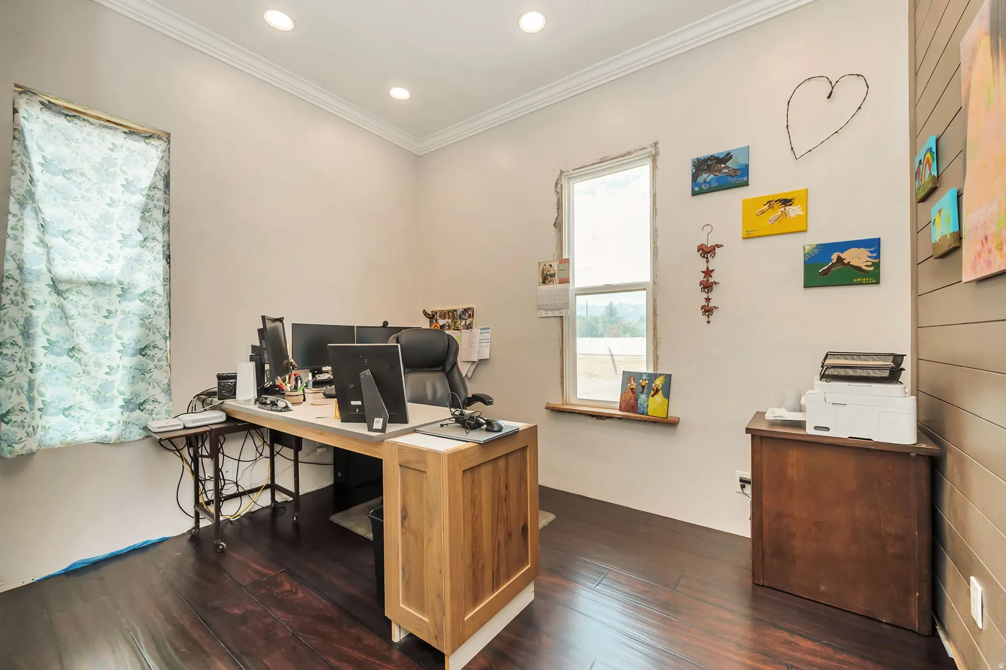 Spacious room featuring rich wood-finish flooring, recessed lighting, and crown molding