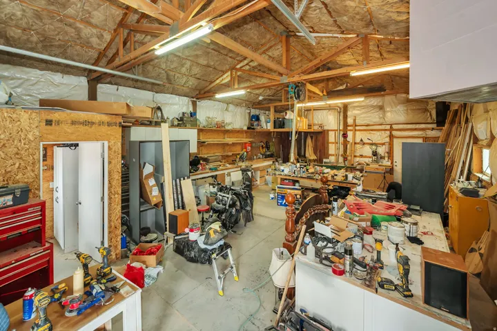 Spacious workshop featuring exposed wood trusses and a concrete floor