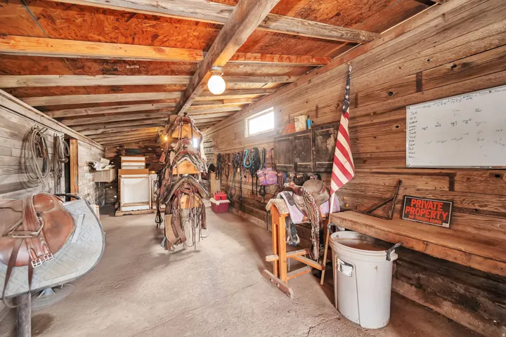 Rustic outbuilding interior featuring exposed wood beams and plank walls