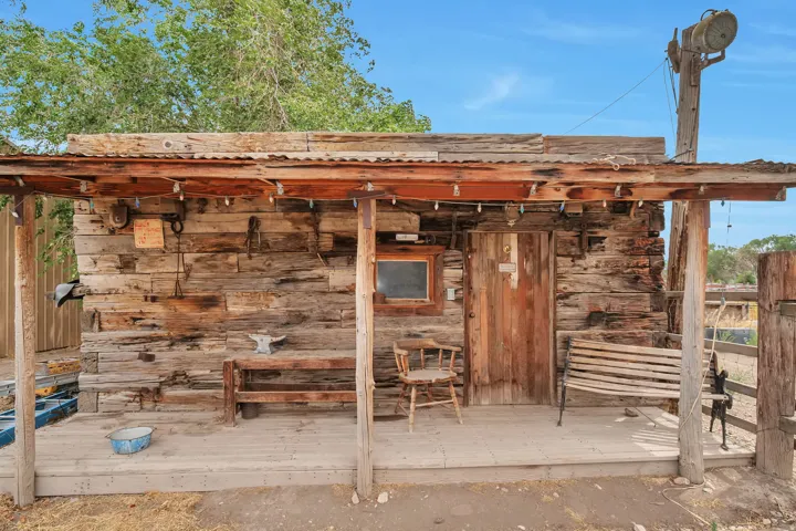 Rustic wood-plank exterior featuring a covered porch with exposed timber beams and a corrugated metal roof