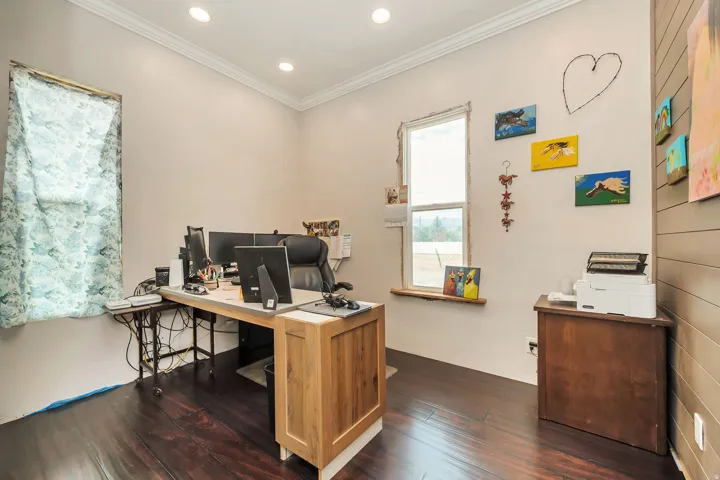 Spacious room featuring rich wood-finish flooring, recessed lighting, and crown molding