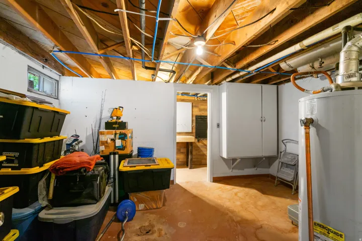 Open ceiling with exposed wood joists and visible utility lines