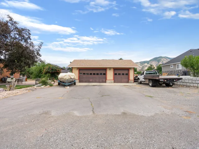 Two-car detached garage with panel wood-finish doors and a shingled roof