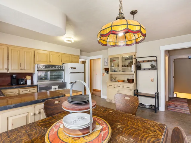 Kitchen featuring solid wood cabinetry, built-in vintage double oven, and refrigerator