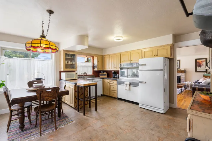 Kitchen featuring light wood cabinetry, vintage built-in oven and refrigerator, and tile flooring