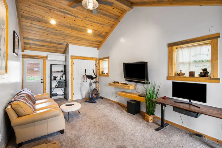Vaulted wood-paneled ceiling with recessed lighting and a ceiling fan