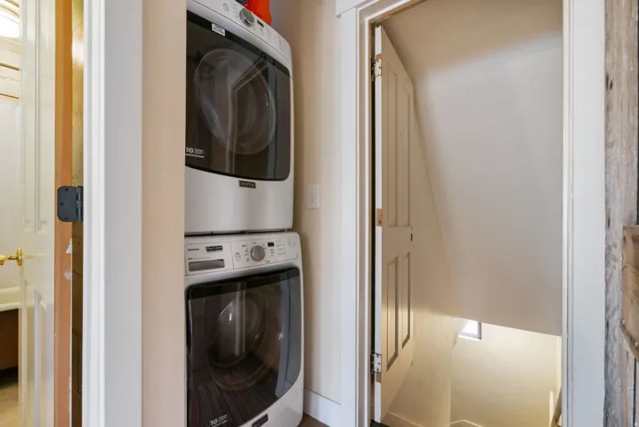 Dedicated laundry area featuring a stacked washer and dryer unit