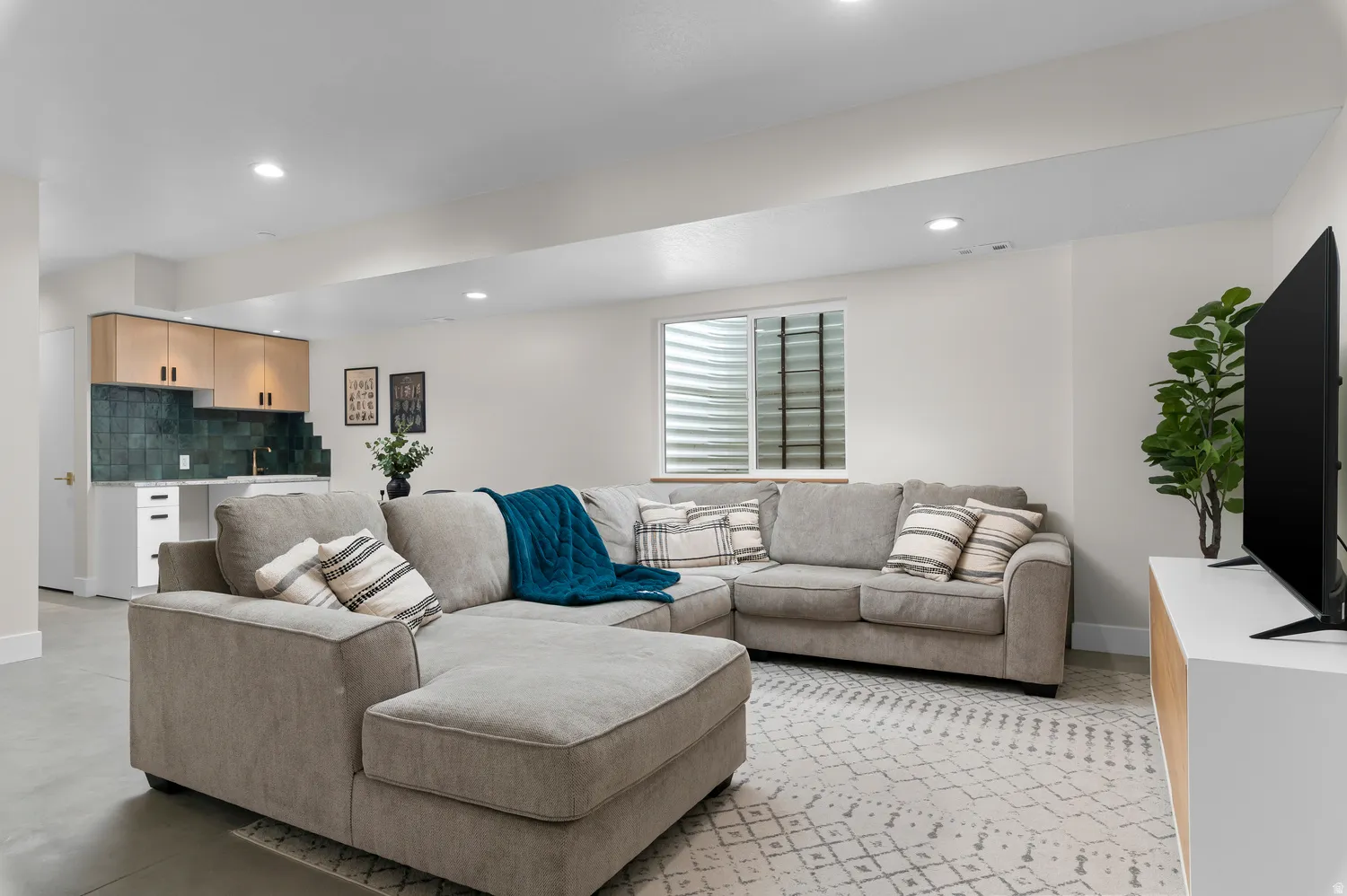 Spacious living area featuring recessed lighting and a window with blinds