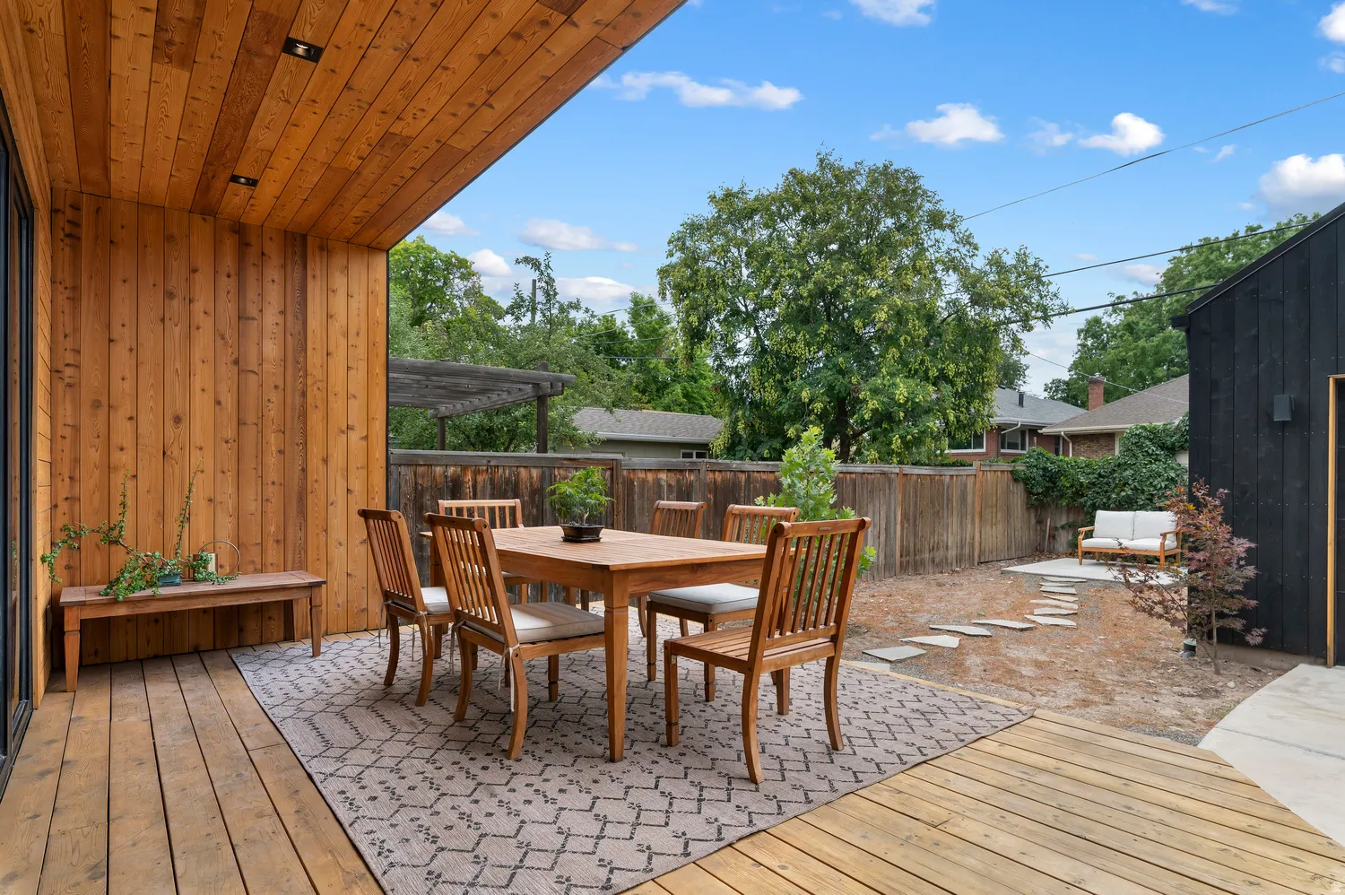 Expansive outdoor deck featuring wood-finish flooring and a wood-paneled ceiling with recessed lighting
