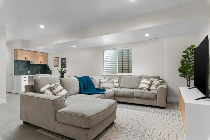 Spacious living area featuring recessed lighting and a window with blinds