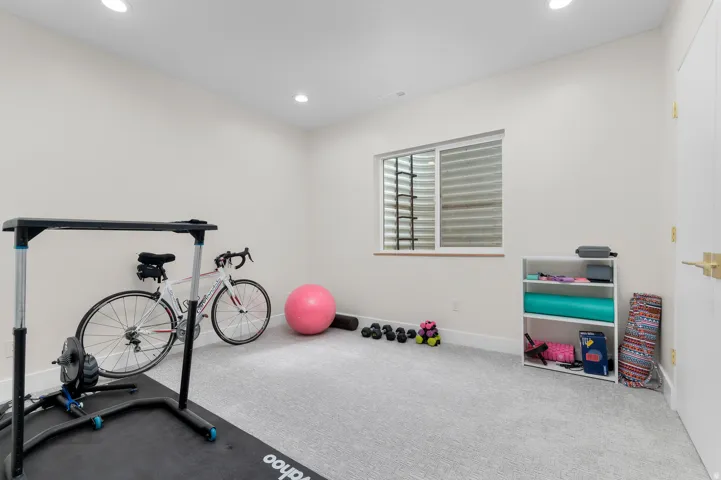 Carpeted room featuring recessed lighting, a window with horizontal blinds, and a built-in wall shelf