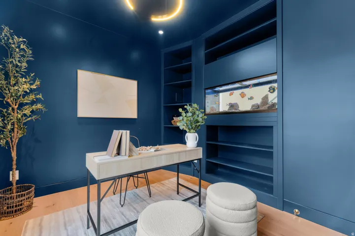 Built-in shelving with an integrated aquarium, hardwood-style flooring, and a contemporary light fixture