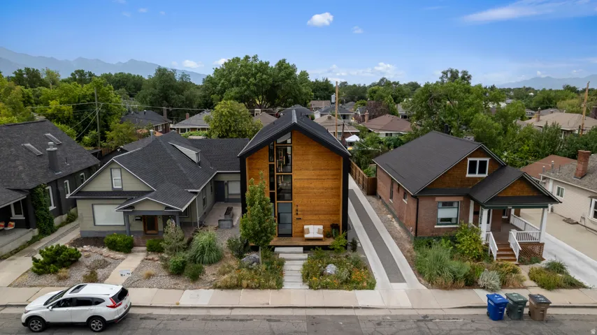 Modern-style home featuring a striking two-story wood-clad facade, a dark gabled roofline, and a multi-pane vertical window array