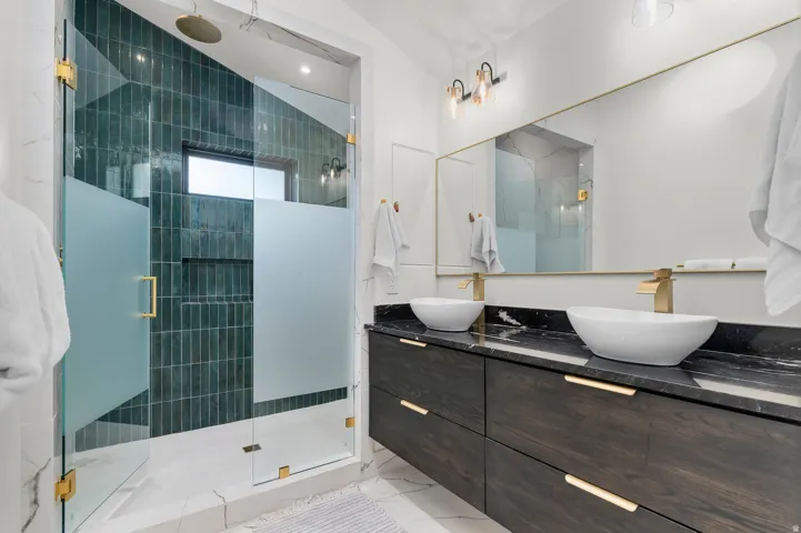 Glass-enclosed shower with dark green subway tile and a built-in niche