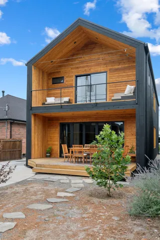 Modern exterior featuring a prominent gabled roofline and natural wood siding